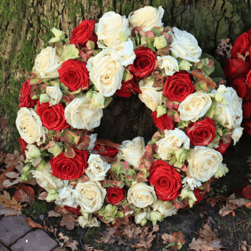 corona funebre con rosas blancas y rojas
