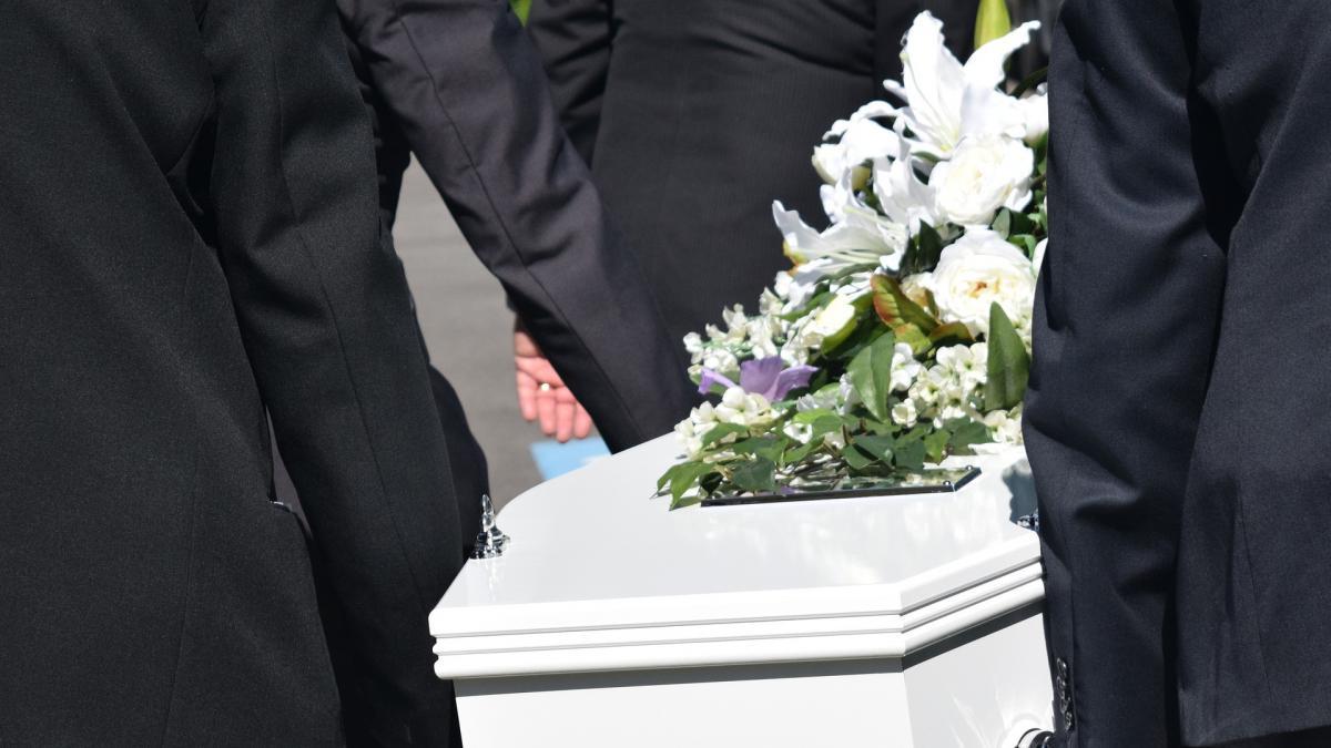 ataud blanco con flores encima