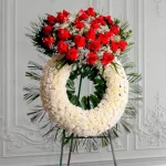 Corona fúnebre de pompones blancos con rosas rojas