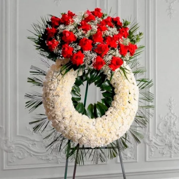 Corona fúnebre de pompones blancos con rosas rojas